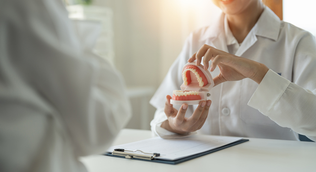 dentist and patient discuss about wisdom teeth removal treatment in dental clinic