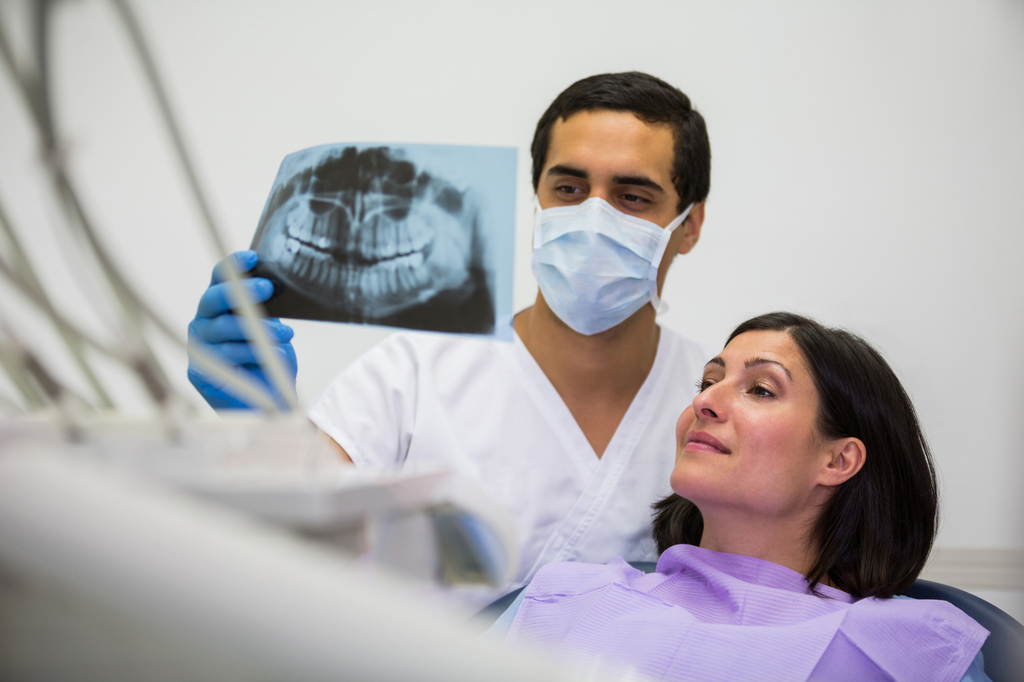 Dentist showing dental x-ray to patient